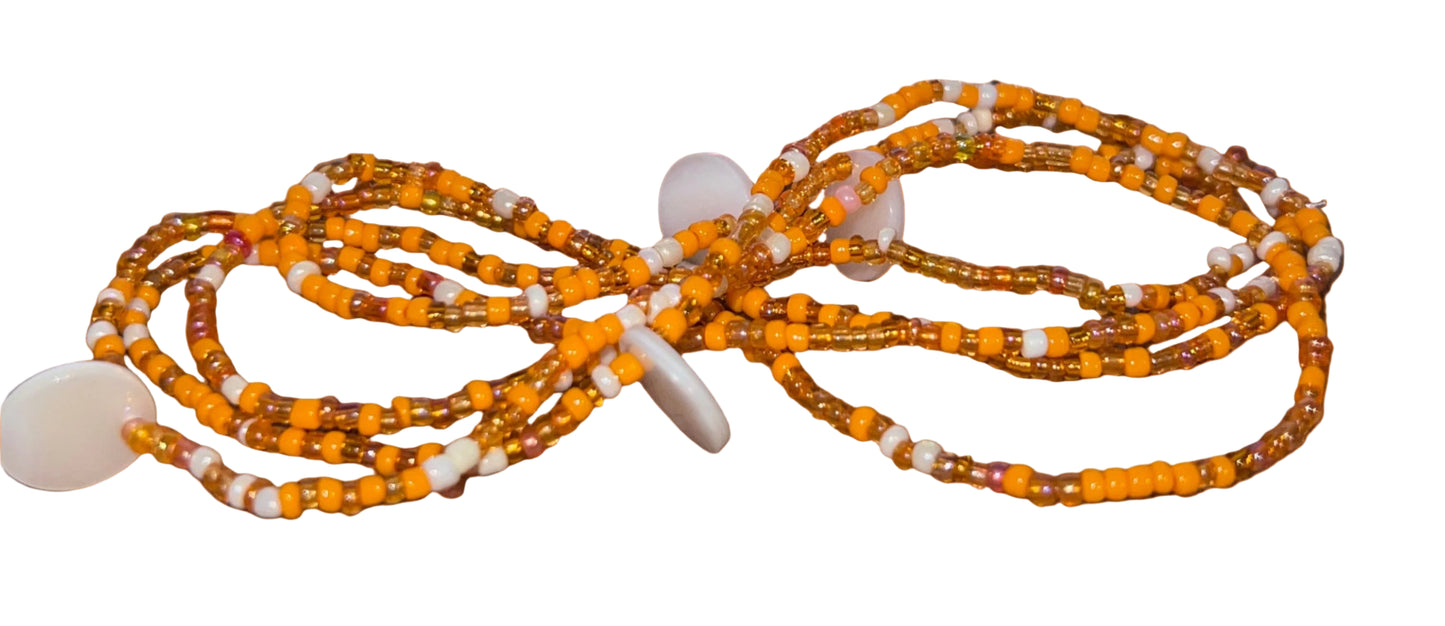 wasitbeads with orange and white beads on a wooden surface