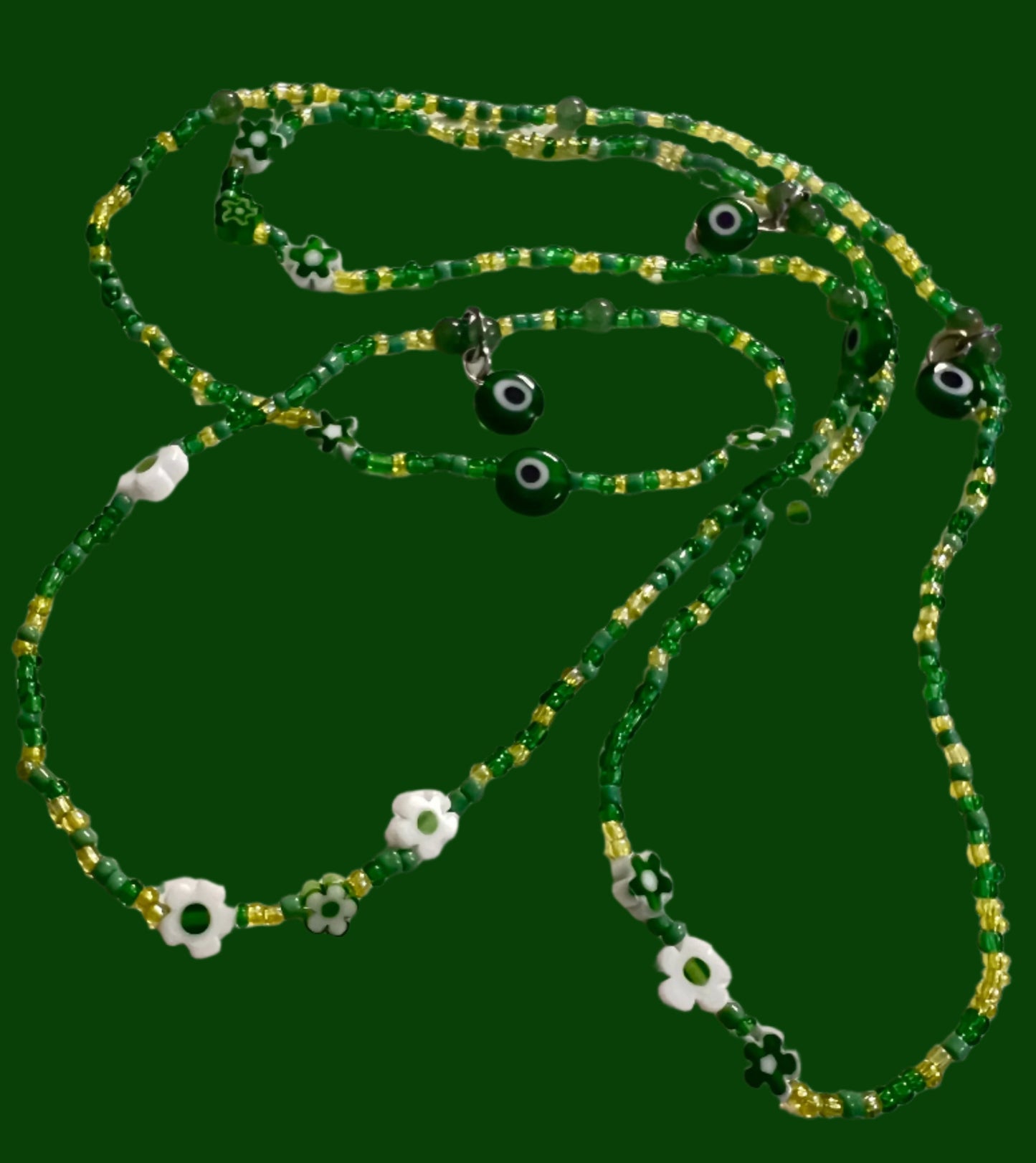 Green waistbeads with eye-shaped beads on a white background