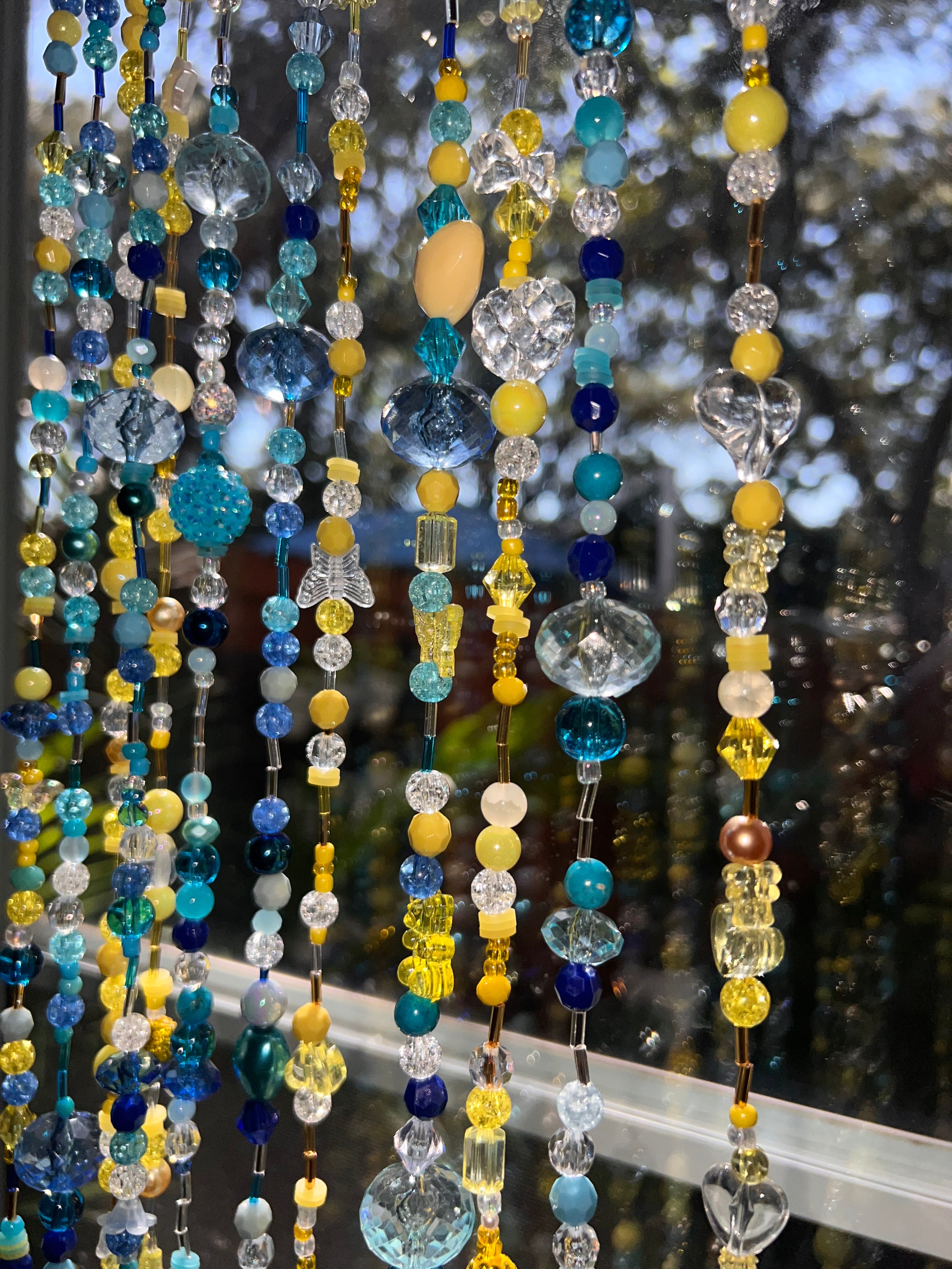 Colorful beaded strands with a blurred natural background