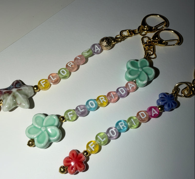 Colorful beaded florida keychain with porcelain flower charms on a white background