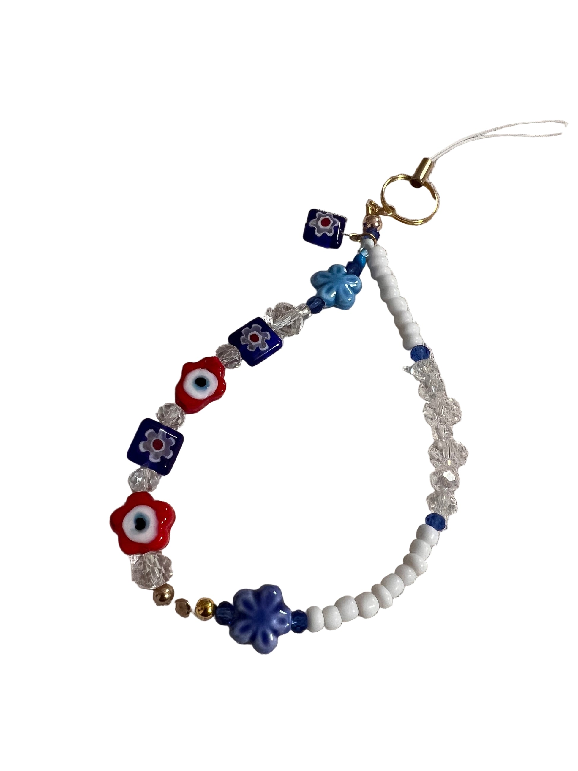 Beaded wristlet with blue, red, and white evil eye designs on a beige background