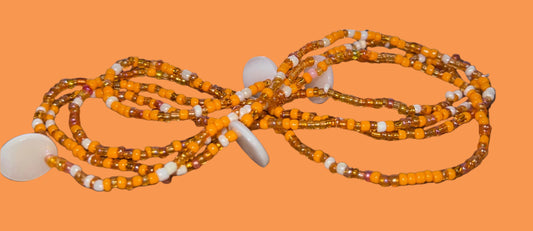 wasitbeads with orange and white beads on a wooden surface 