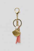 Handbag with decorative charm featuring a peach tassel, gold shell, and freshwater pearl.
