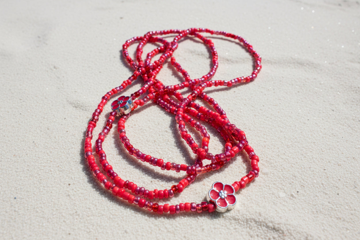Red waistbeads on sandy background 