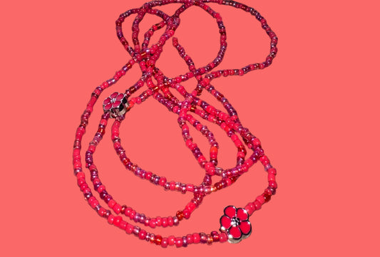 Red waistbeads on a wooden surface 