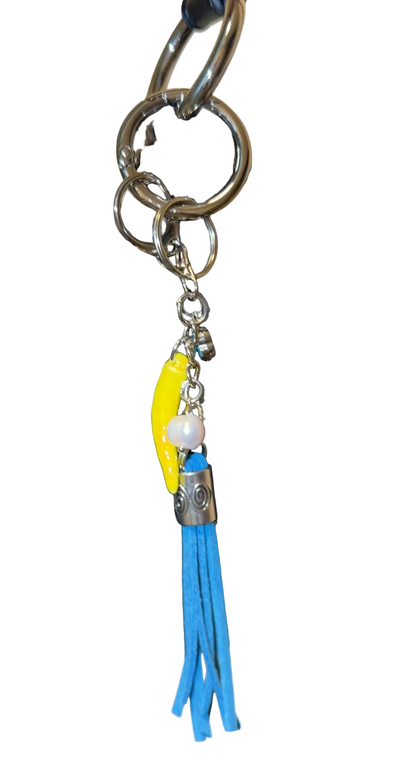 Handbag with decorative charm featuring a blue tassle ,freshwater pearl, porcelain pepper charm