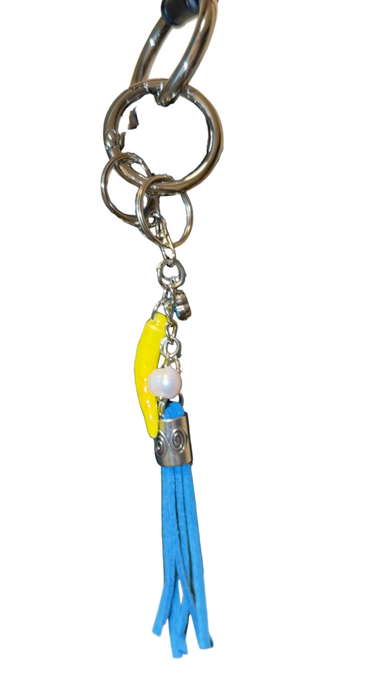 Handbag with decorative charm featuring a blue tassle ,freshwater pearl, porcelain pepper charm