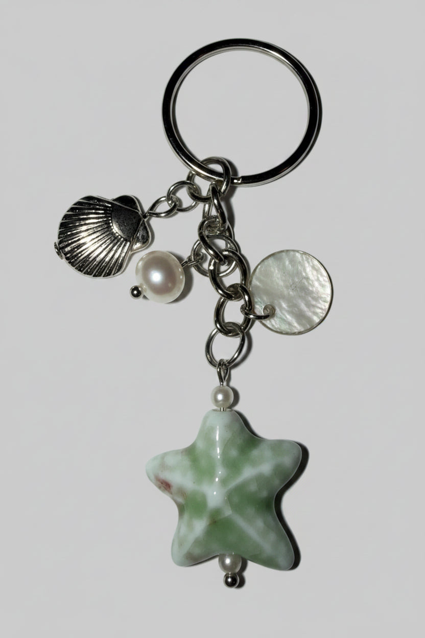 Silver keychain with star-shaped porcelain charm, shell, and pearl