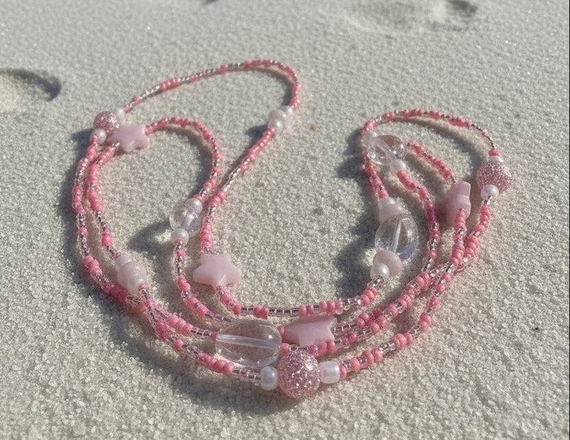 baby pink waistbeads made by gabi decor studio with pink stars, moonstone beads and pink reflective beads
