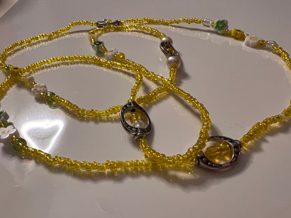 Yellow seed bead waistbeads necklace on a white surface