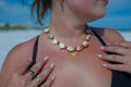woman wearing a necklace with a starfish pendant on a beach