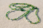 Green beaded wasitbeads with evil eye charms on a white background