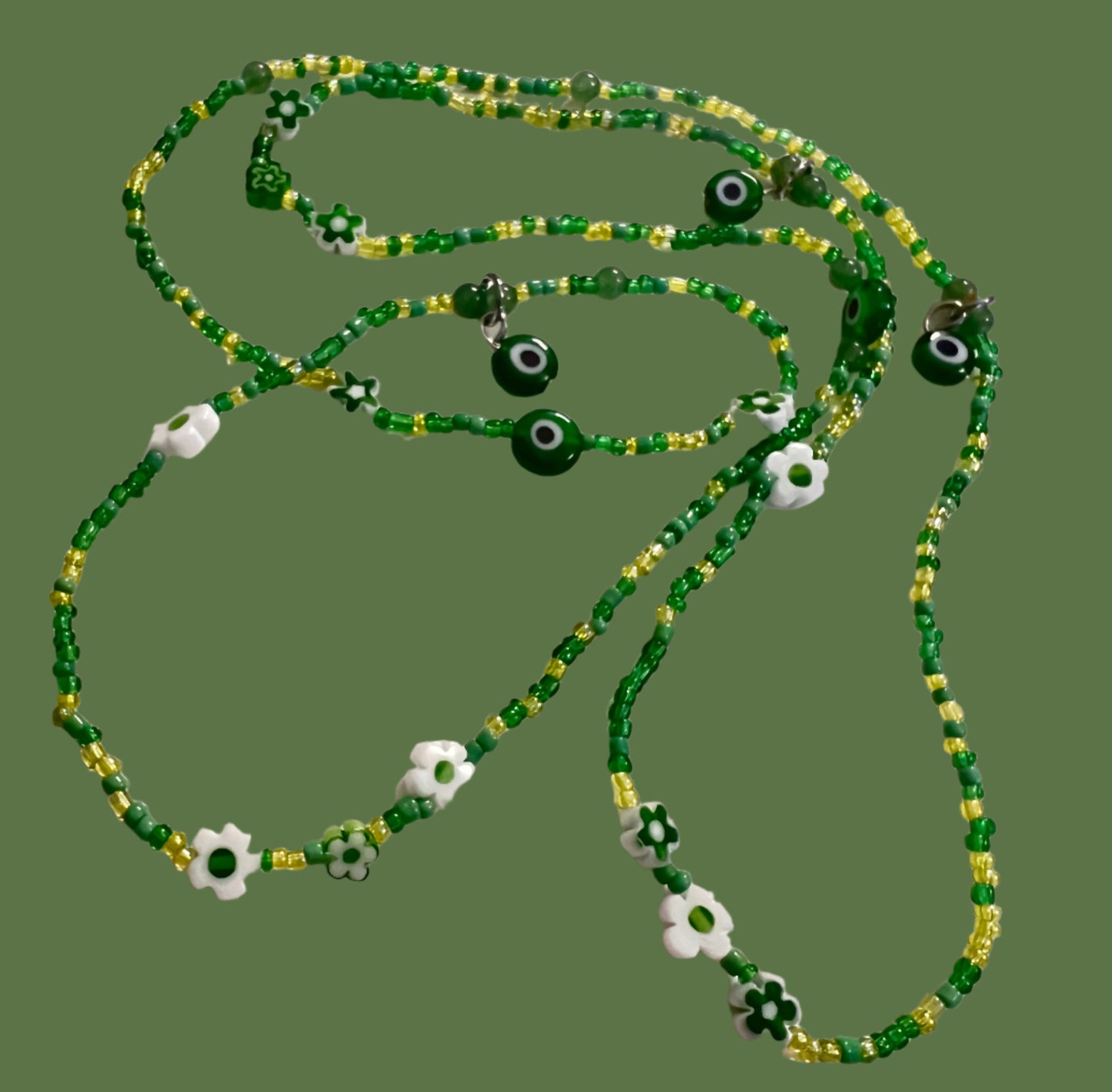 Green beaded wasitbeads with evil eye charms on a white background