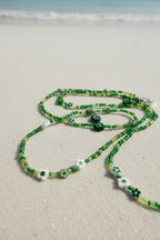 Green waistbeads with eye-shaped beads on a white background
