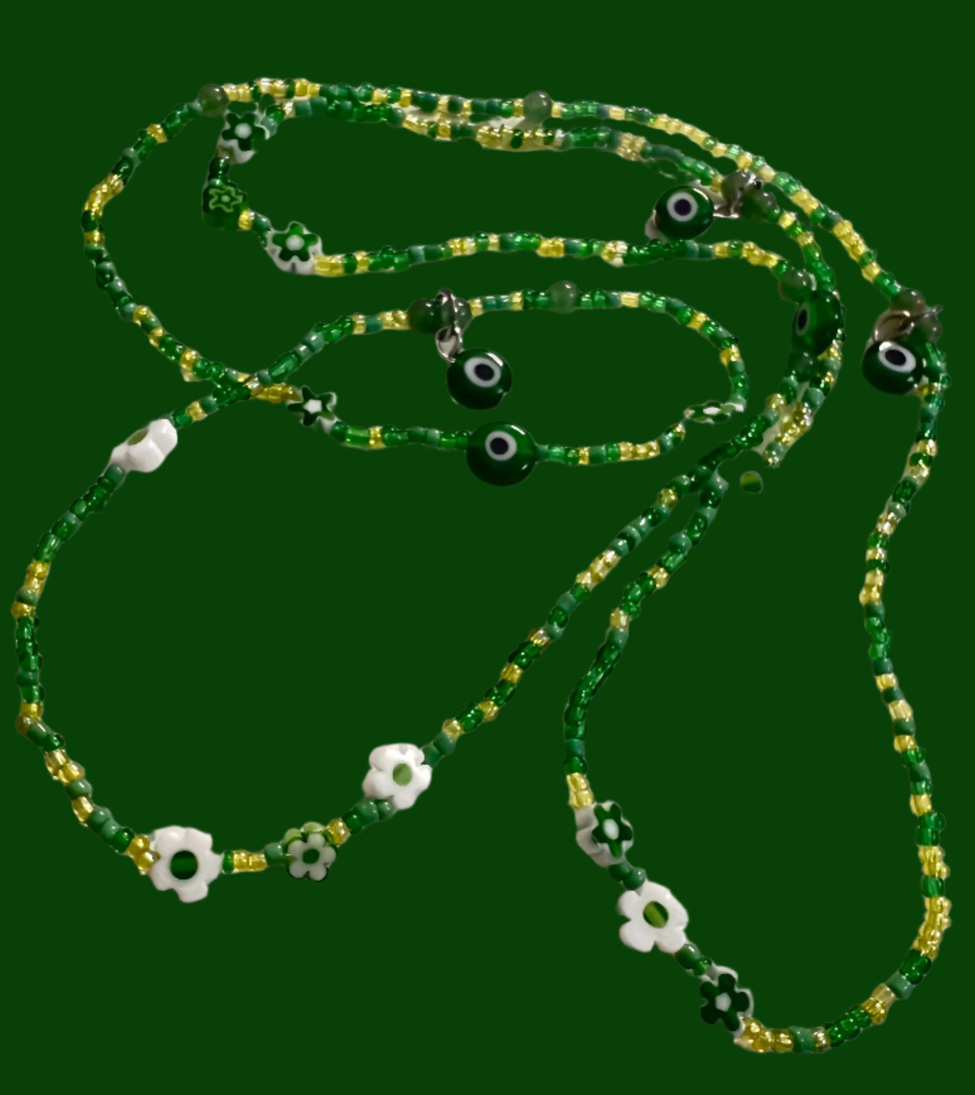 Green waistbeads with eye-shaped beads on a white background
