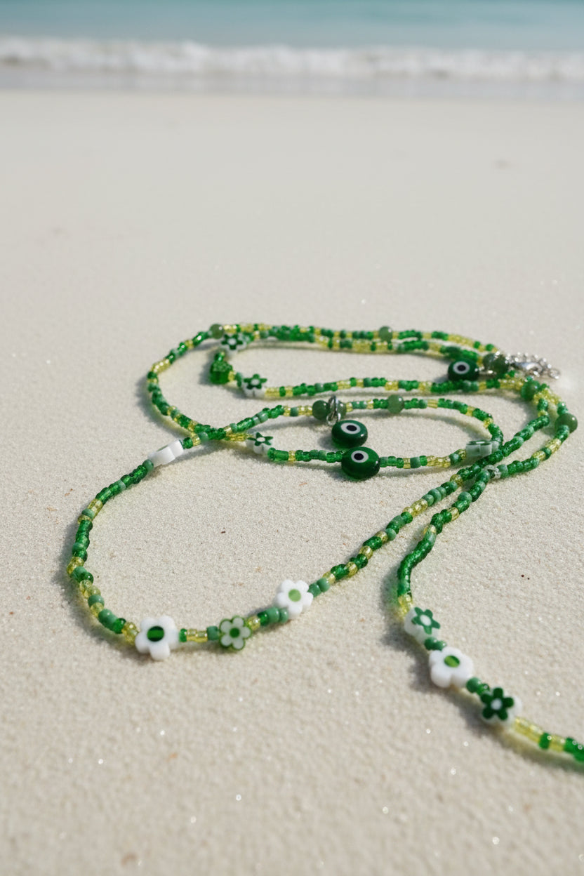 Green waistbeads with eye-shaped beads on a white background