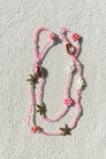 pink and white waistbeads with clay flowers, gold cowrie shells and starfish, pink and white plastic starfish beads
