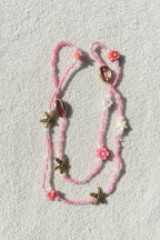 pink and white waistbeads with clay flowers, gold cowrie shells and starfish, pink and white plastic starfish beads