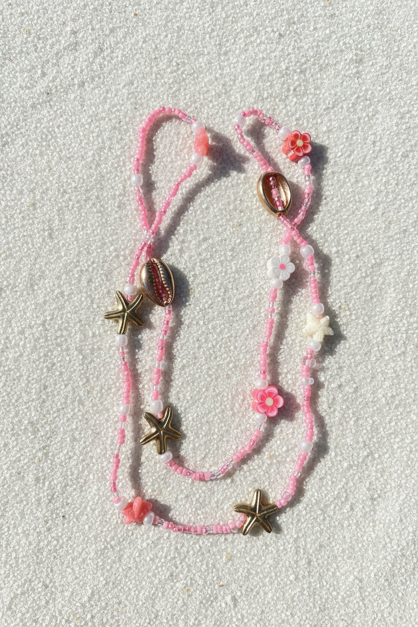 pink and white waistbeads with clay flowers, gold cowrie shells and starfish, pink and white plastic starfish beads