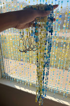 Hand holding a bundle of colorful beaded strands
