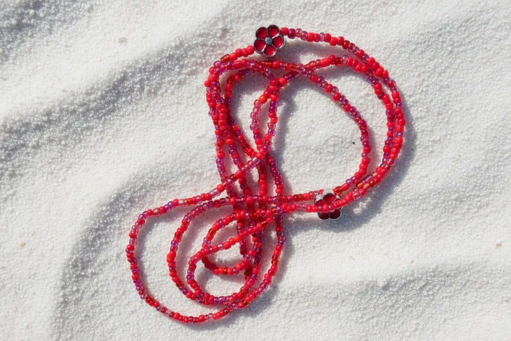 red waistbeads with red metal flowers