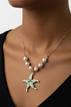 Gold necklace with a starfish pendant and pearls