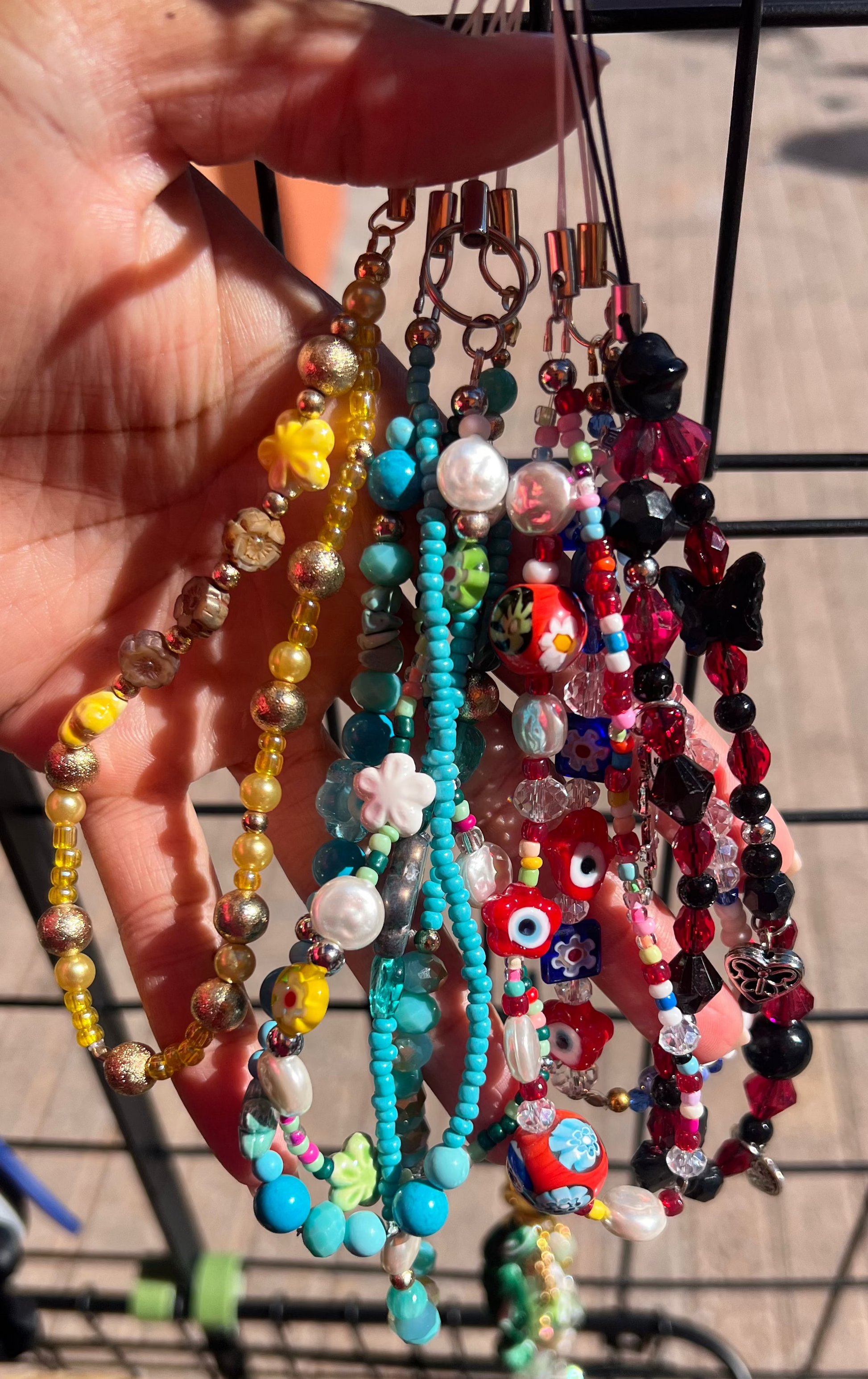 Hand holding colorful beaded wristlets 